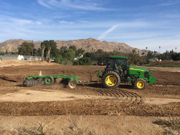 Green tractor with rotortiller in field