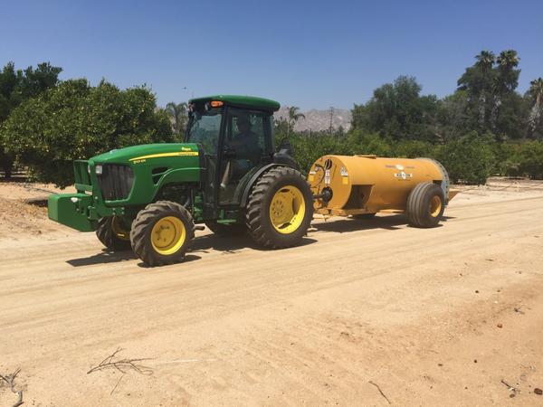 Tractor on road with sprayer attached